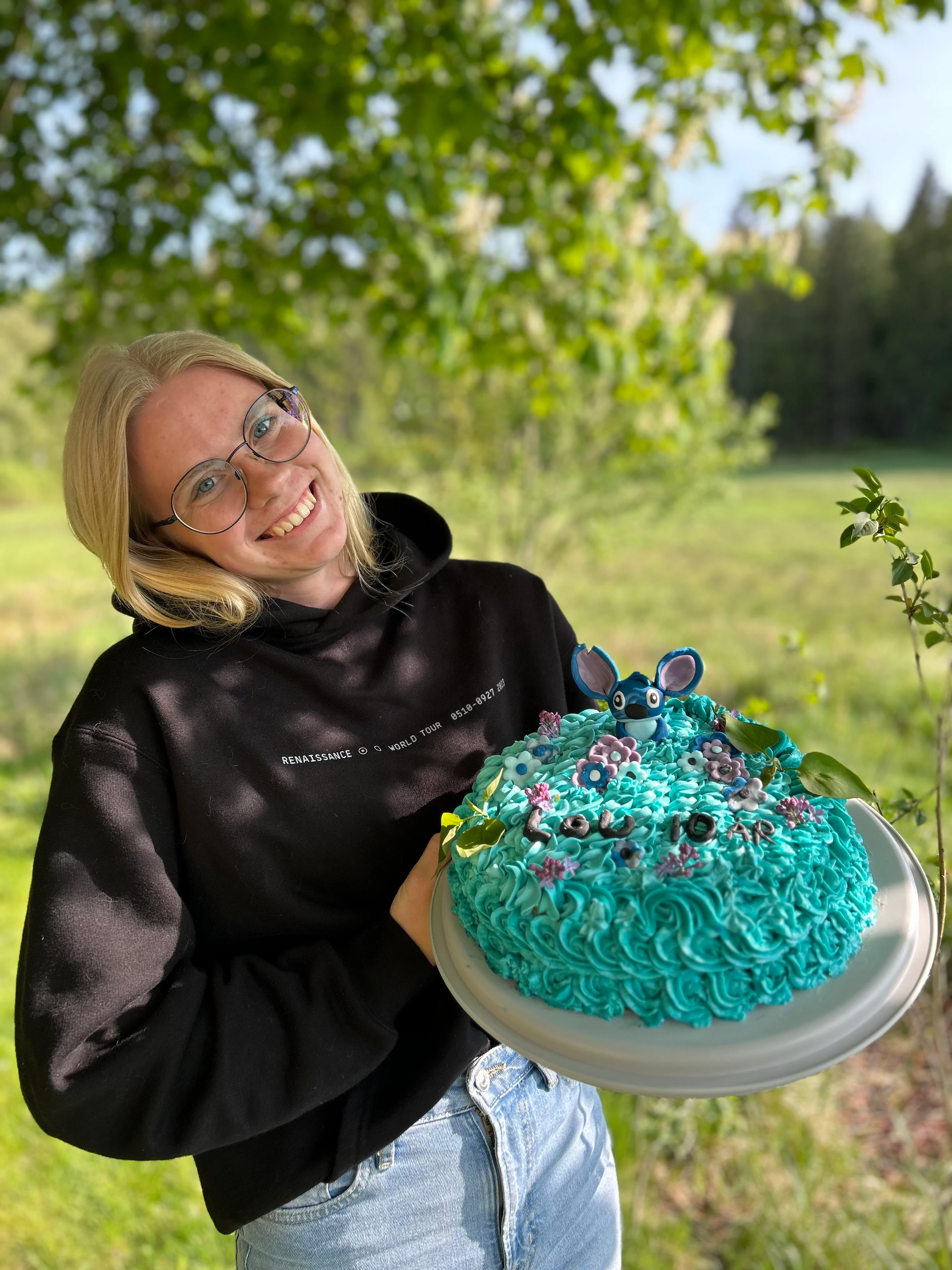 Josefine håller i en tårta med figuren Stitch på