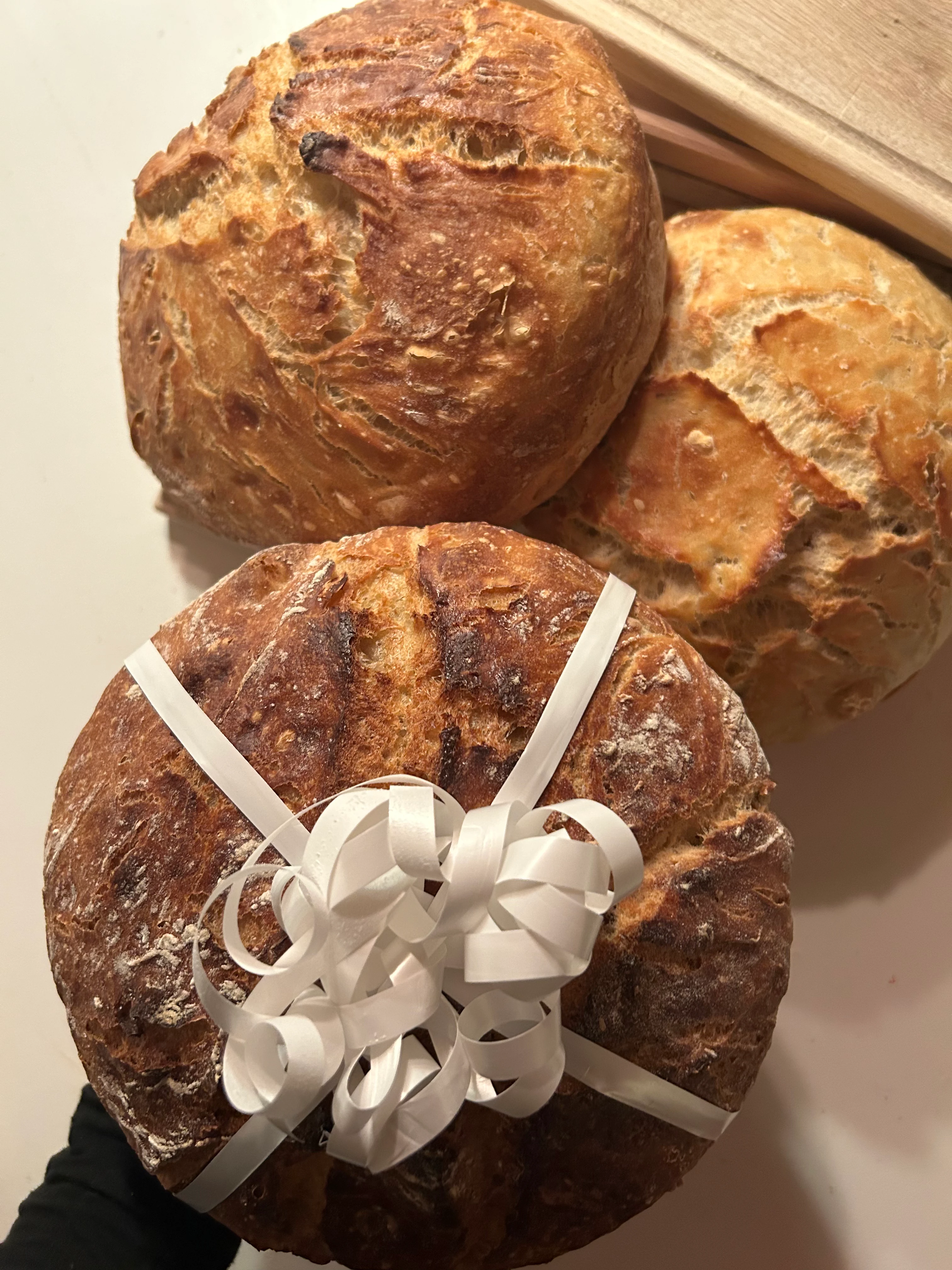 Tre vackra gräddade runda bröd med ett med presentsnöre runt