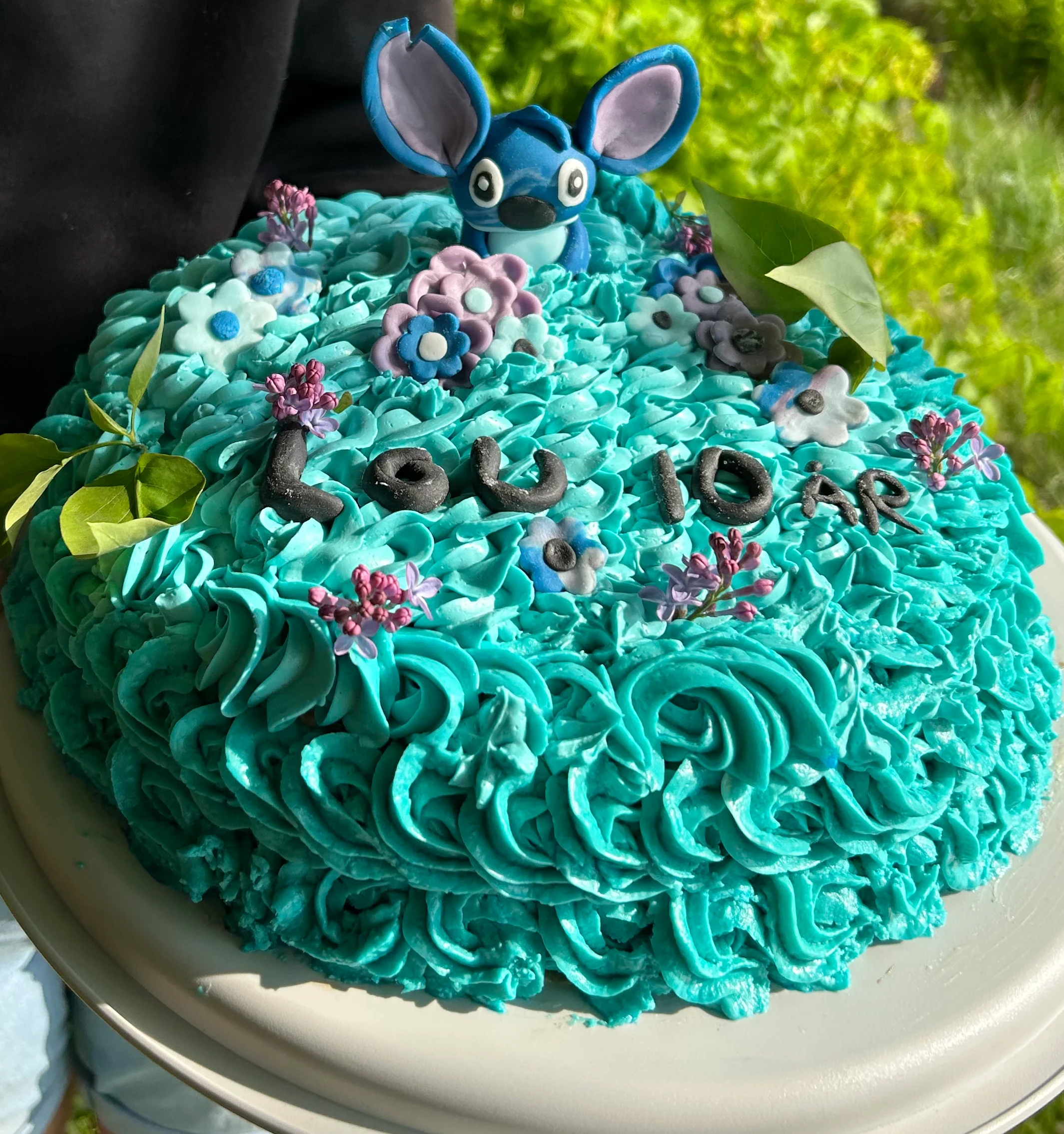 Blå tårta till barnkalas dekorerad med en figur som ser ut som Stitch